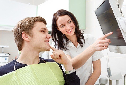 Dentist and patient reviewing images on computer
