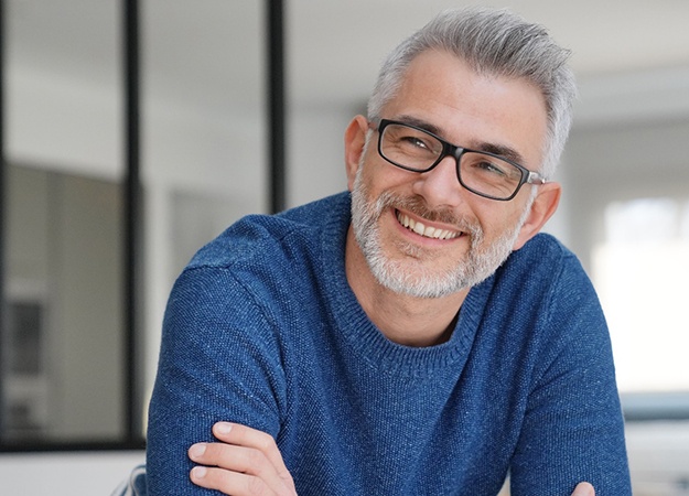 Man in blue shirt wearing glasses and smiling