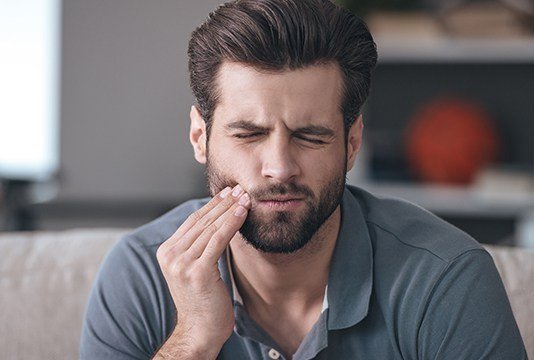 Man in pain holding jaw