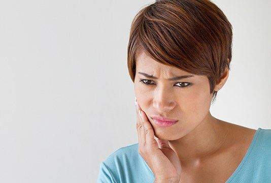 Woman in pain holding jaw