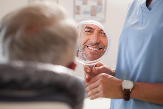 Man looking at smile in mirror