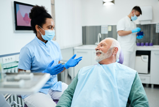 Male denture candidate in Raleigh talking to dentist