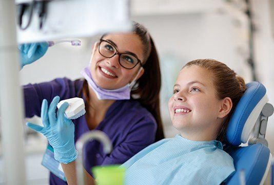 Dentist and child looking at computer screen