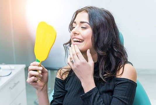 Woman looking at smile in mirror