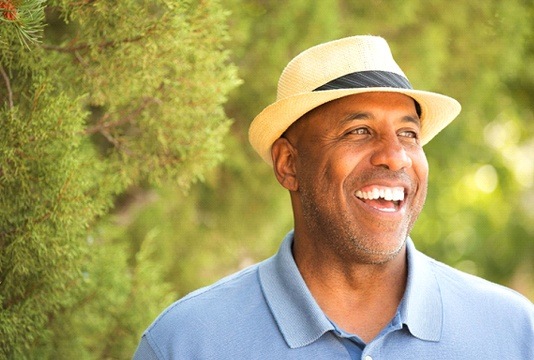 man in hat standing in trees