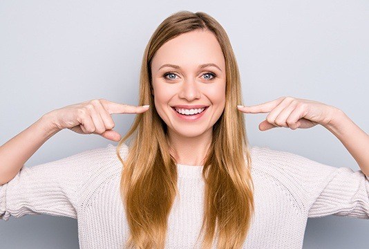 Woman pointing to her beautiful smile