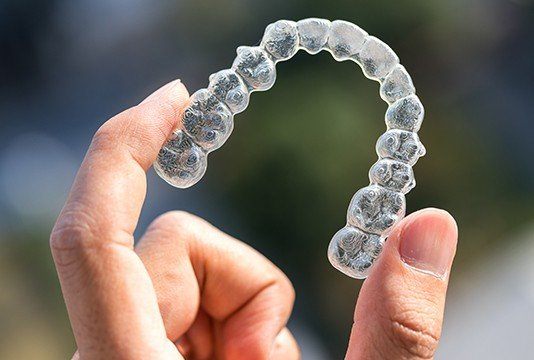 Hand holding a clear aligner