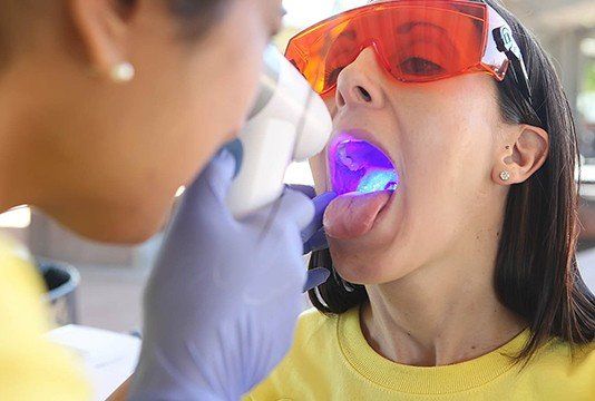 Woman receiving oral cancer screening