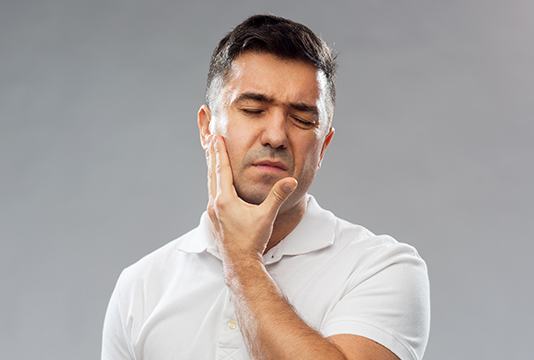 Man holding jaw in pain