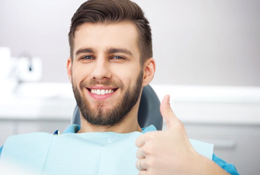 a dental patient giving thumbs up