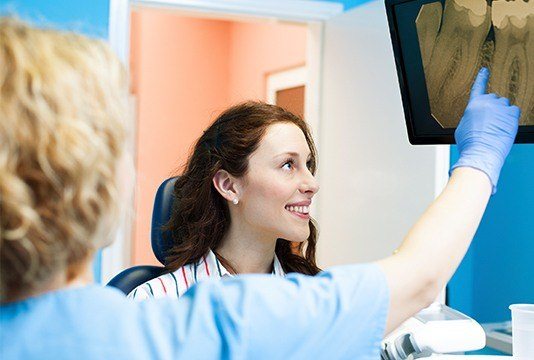 Dentist and patient looking at digital x-rays