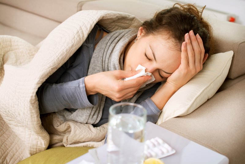 Closeup of woman with a cold resting on couch