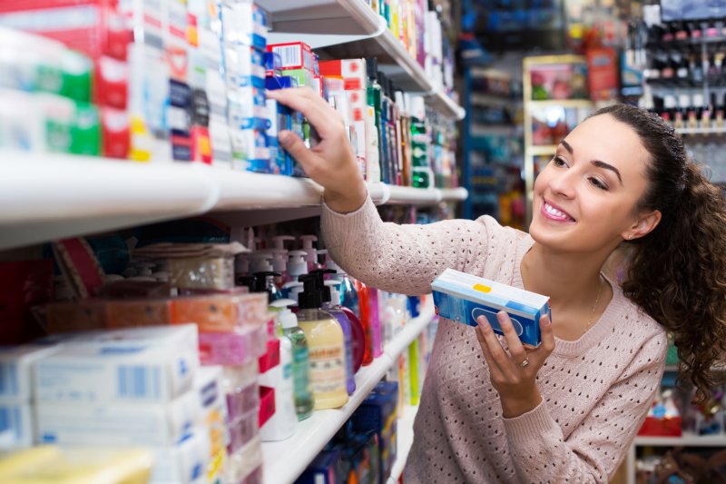 A woman buying over-the-counter teeth whitening products in Raleigh