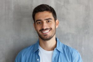 Young man with straight teeth smiling. 
