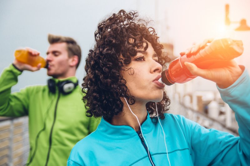 Man and woman drinking a sports drink