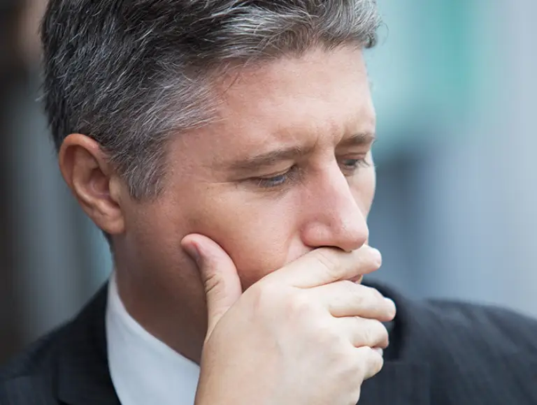Man in business suit covering his mouth