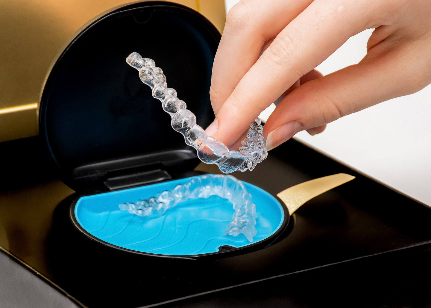 Dentist placing clear aligner on smiling patient